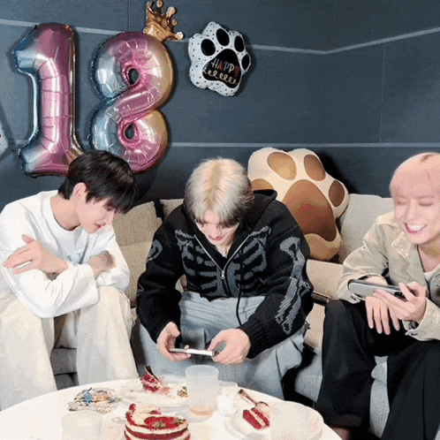 a group of people sitting on a couch with a balloon that says 18 on it