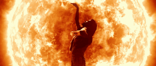 a silhouette of a woman standing in front of a fire circle