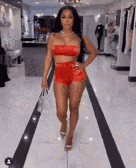 a woman in a red bikini is walking down a hallway .