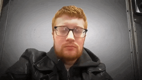 a man with a beard and glasses is wearing a black leather jacket