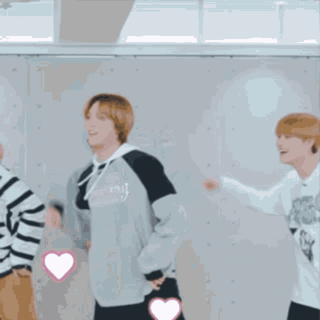 a group of young men are standing next to each other in a room .