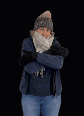 a woman with her arms crossed wearing a scarf and beanie