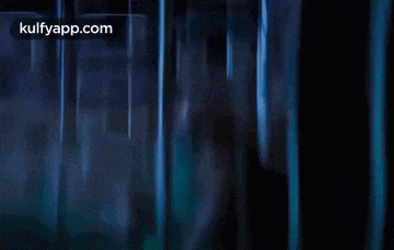 a man is holding a cell phone in a dark room .