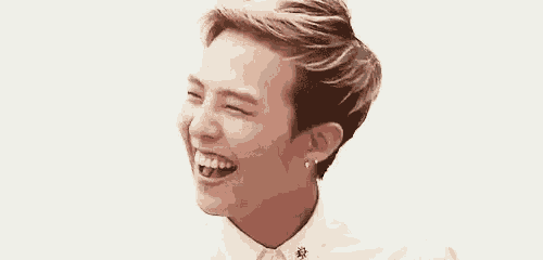 a young man is laughing while wearing a white shirt and tie .