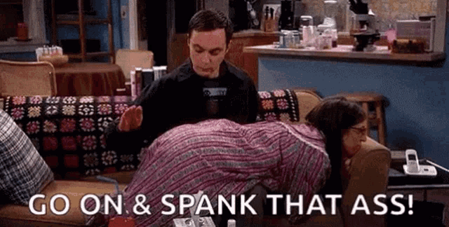 a man is spanking a woman on a couch with the words `` go on and spank that ass '' .