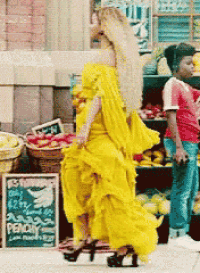 a woman in a yellow dress stands in front of a sign that says " peach "