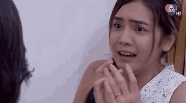 a woman with a ring on her finger is looking at another woman 's face .