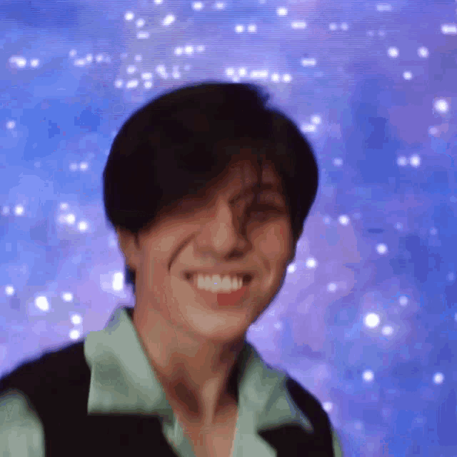 a close up of a person 's face with a blue background and a smile on their face .