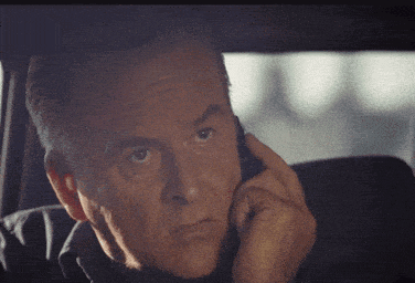 a man is talking on a cell phone in a car