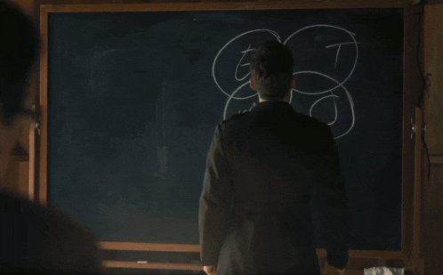 a man in a military uniform stands in front of a blackboard with a drawing on it
