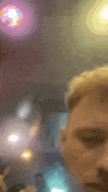 a blurry picture of a person 's face with a purple light behind them