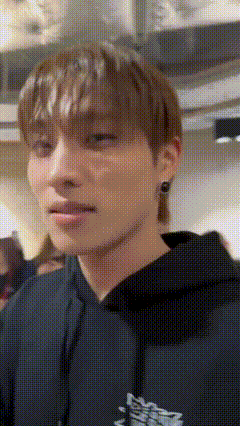a close up of a young man wearing a black hoodie .