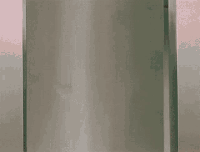 a girl in a green dress is peeking out from behind a door