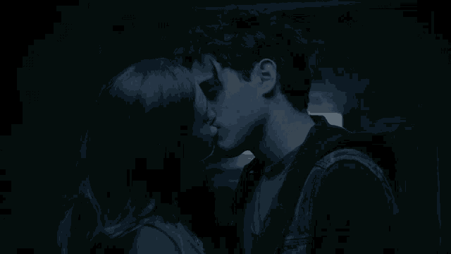 a man and a woman looking at each other in the dark