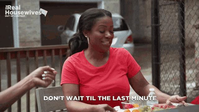 a woman sitting at a table with the words " do n't wait til the last minute " on her face