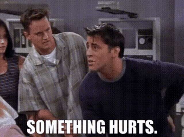 two men standing next to each other with the words something hurts on the bottom right