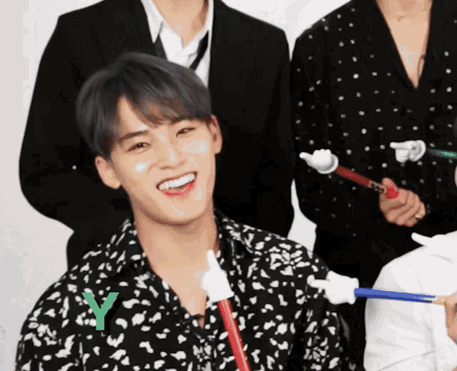 a man holding a toothbrush with the letter y on his shirt