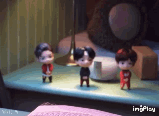 three dolls are standing on a table with imgplay written in the corner