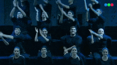 a group of people in black shirts are standing in a row