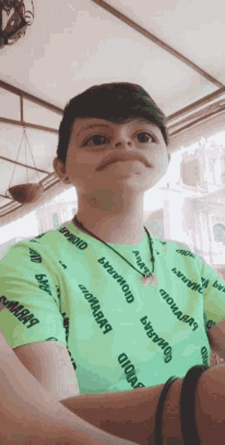 a person wearing a green shirt that says ' oioioioioioio ' on it