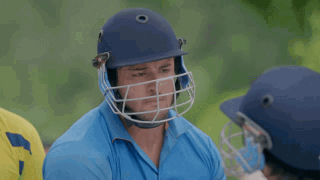a person wearing a blue helmet with a cage around their face