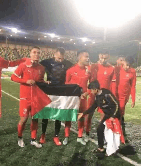 a group of soccer players are posing for a picture on a field .