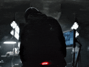 a man riding a motorcycle in a dark room