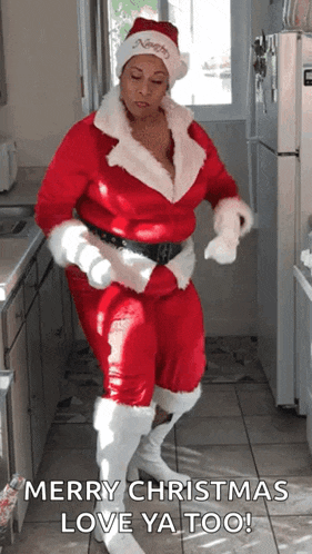 a woman in a santa suit is dancing in a kitchen