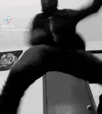 a black and white photo of a man in a mask jumping in the air .