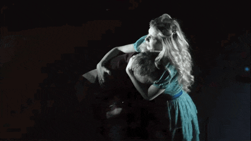 a man and a woman are hugging in a dark room .