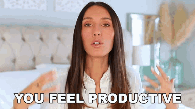a woman in a white shirt is sitting on a bed and says you feel productive