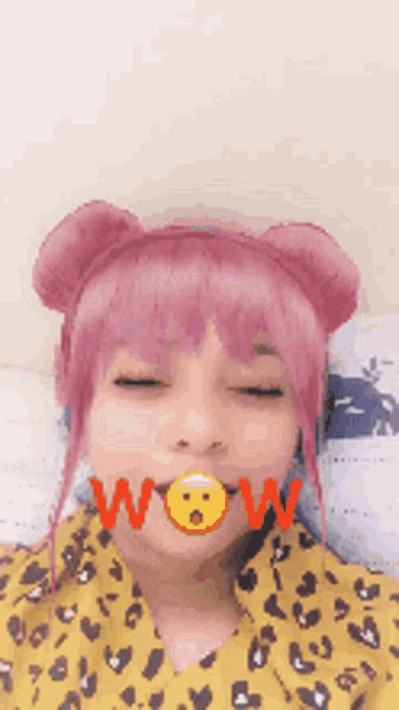 a girl with pink hair is wearing a leopard print shirt and has a smiley face in her mouth .