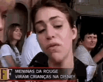 a woman is making a funny face while standing in front of a crowd .