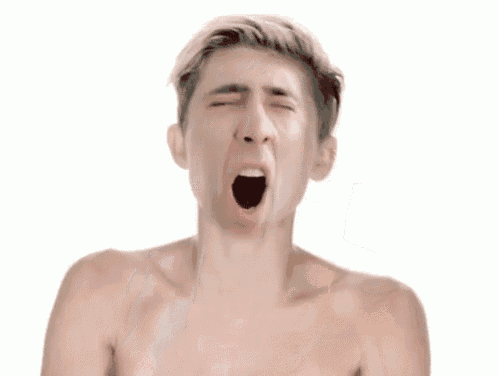 a shirtless man is making a funny face with his mouth open and his hands on his head .