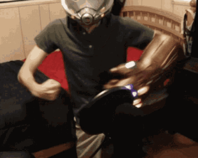 a man wearing a helmet is holding a pair of boots