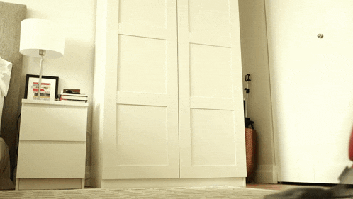 a bedroom with a wardrobe and a lamp