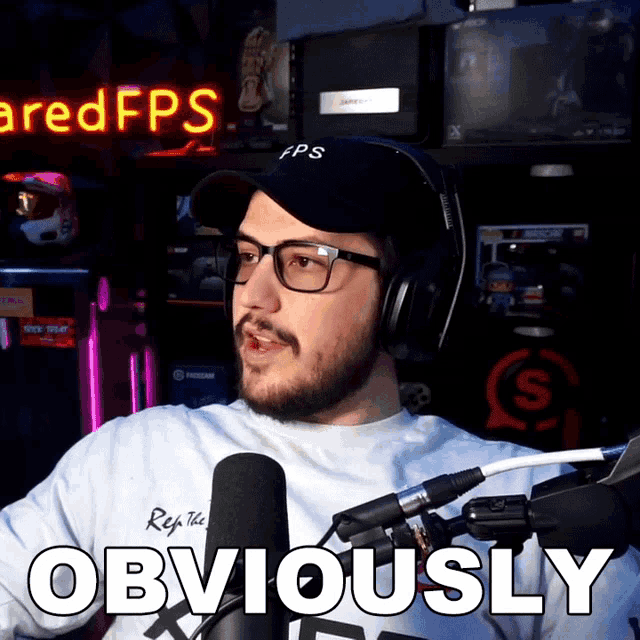 a man wearing glasses and headphones says obviously in front of a microphone