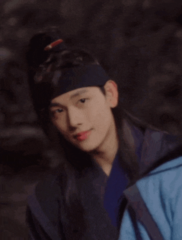 a young man in a traditional costume with a headband around his head