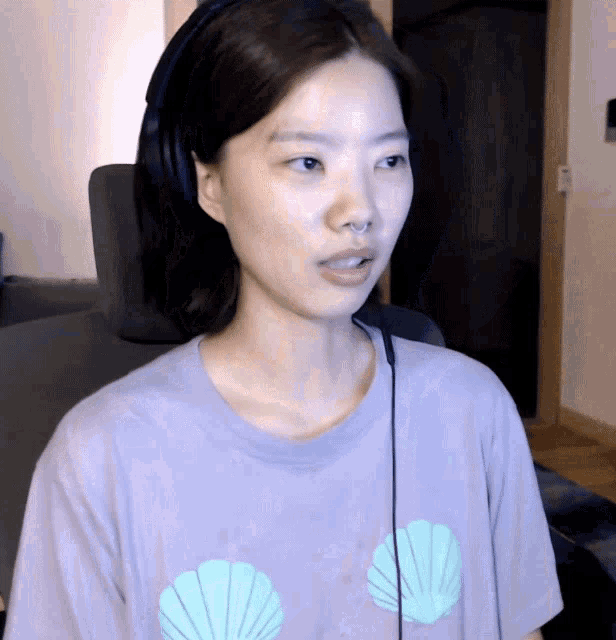 a woman wearing a purple shirt with shells on it