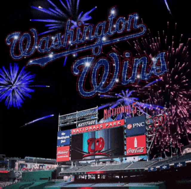 a washington nationals stadium with fireworks behind it