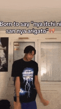 a man wearing a black shirt with lightning on it is dancing in a room