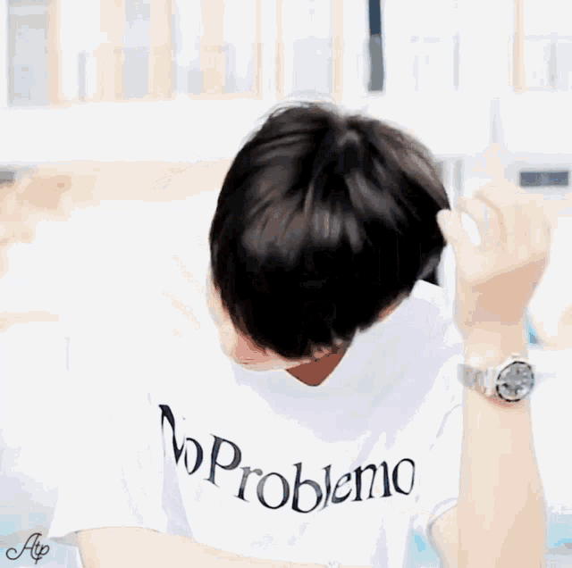 a person wearing a white shirt that says no problemo on it