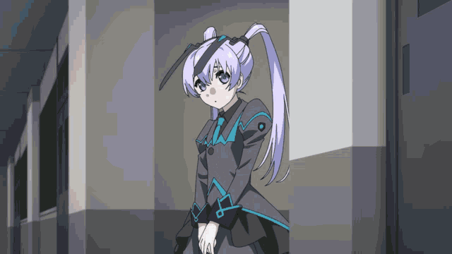 a girl in a gray and blue dress stands in a hallway with her hands folded