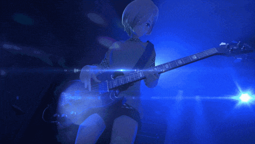 a person playing a guitar in a dark room with blue lights