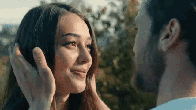 a man and a woman are touching each other 's foreheads .
