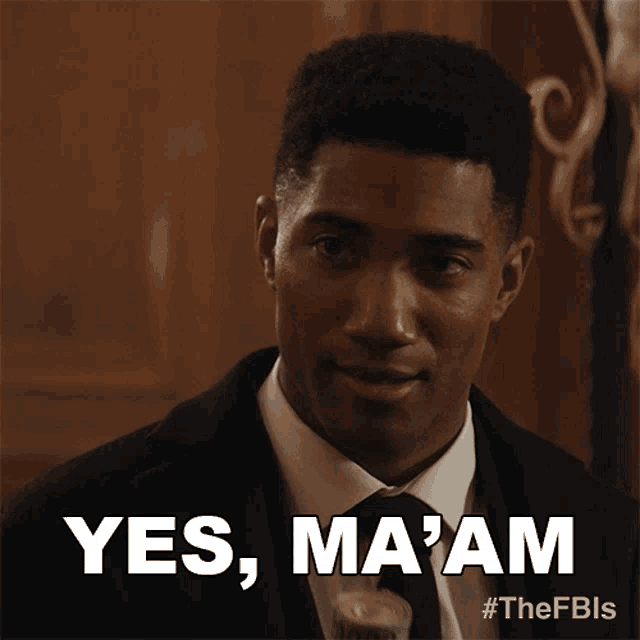 a man in a suit and tie is saying yes ma am