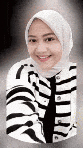 a woman wearing a white hijab and a striped jacket smiles for the camera