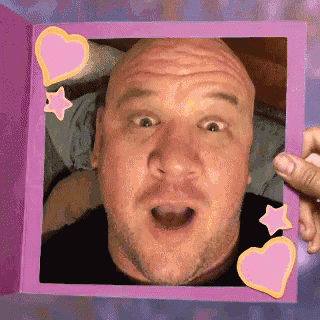 a man is making a funny face in a pink frame with hearts and stars