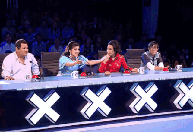 a group of people are sitting at a table with a sign that says xxx