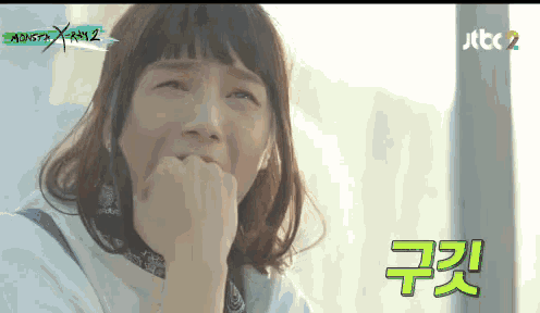 a woman is laughing in front of a jtbc sign